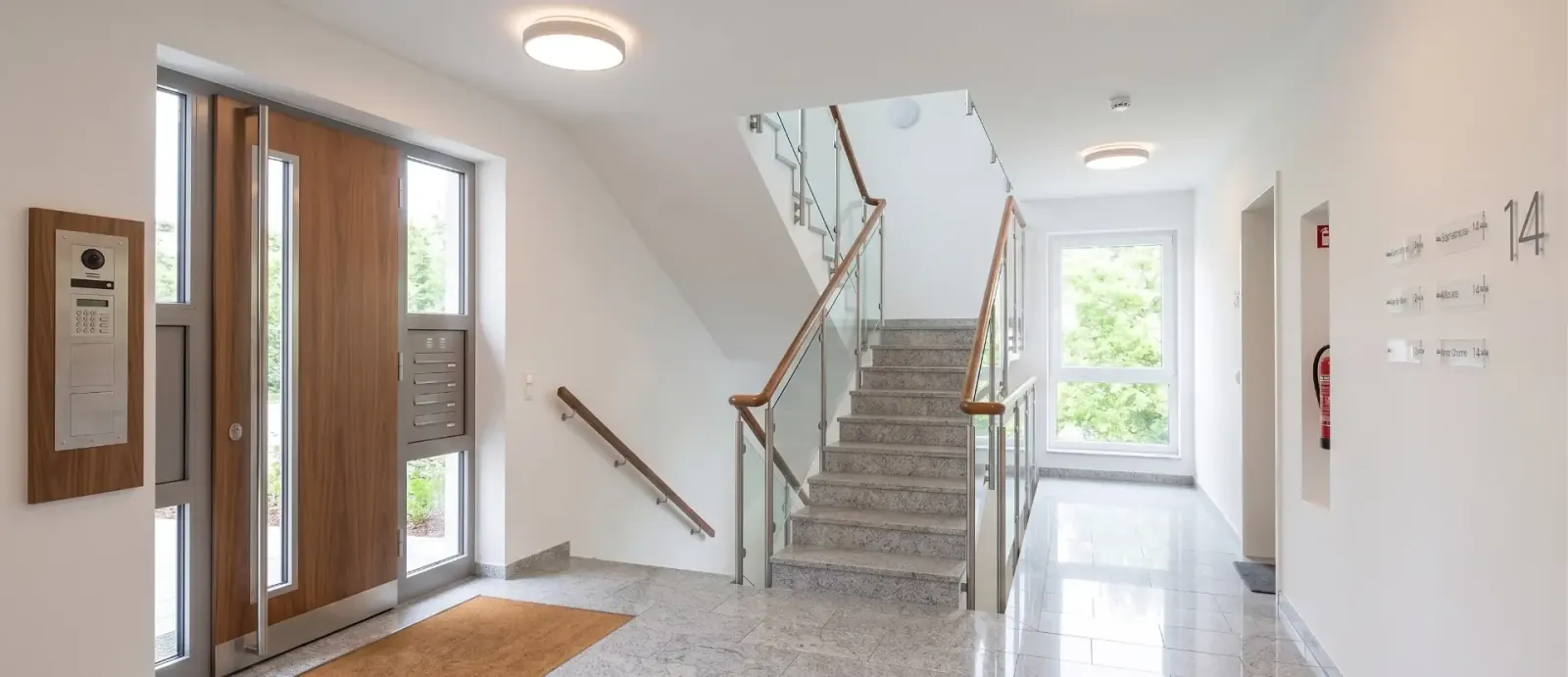 Heller Eingangsbereich eines Mehrfamilienhauses nach der Treppenhausreinigung.