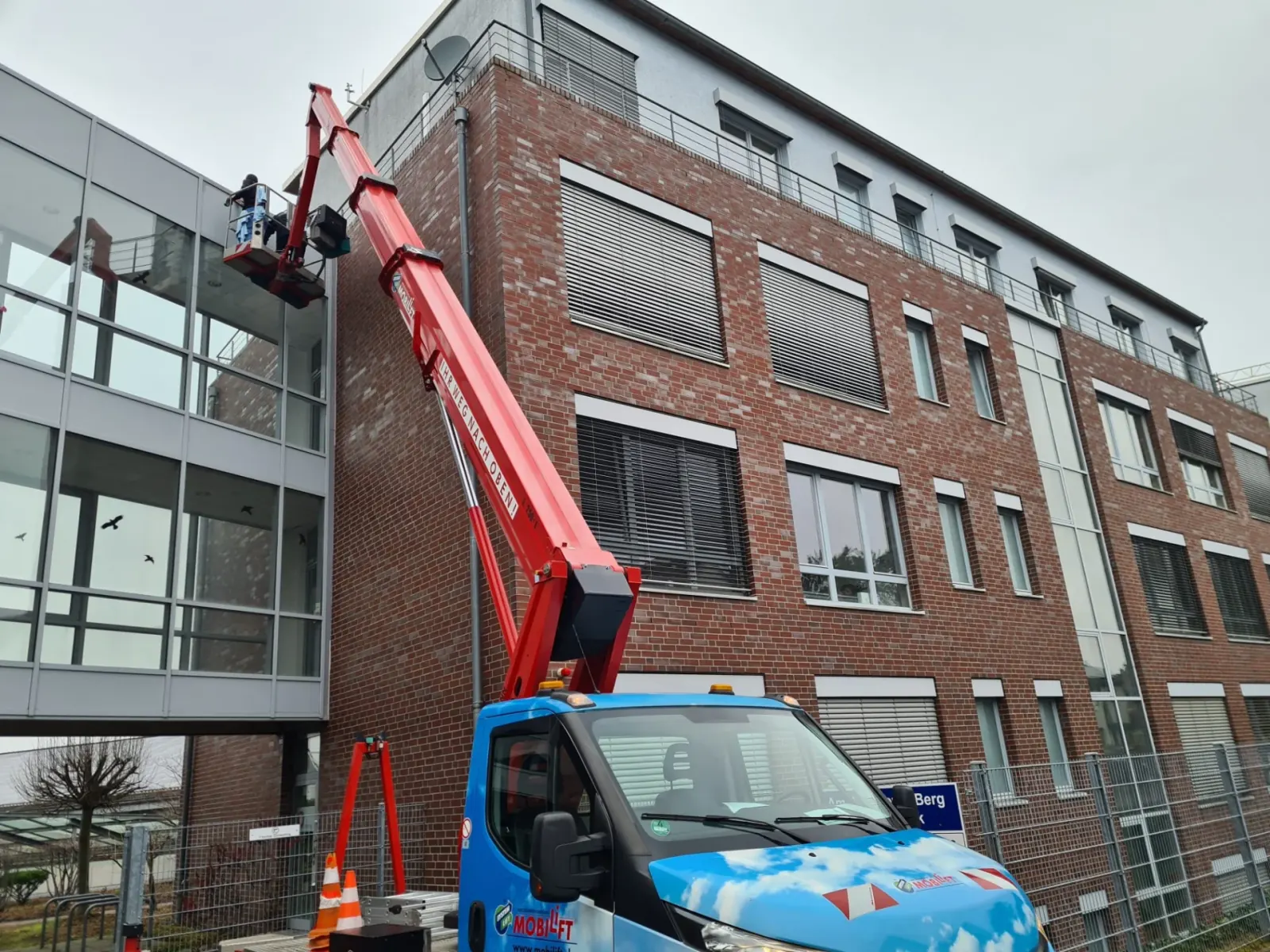 Hebebühne an einer hohen Glasfassade beim Reinigungseinsatz