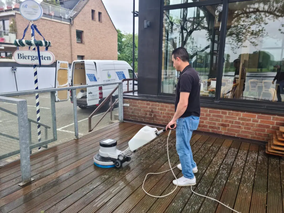 Holzterrassenreinigung am Restaurant mit Einscheibenmaschine, My Clean Center Mitarbeiter im Einsatz