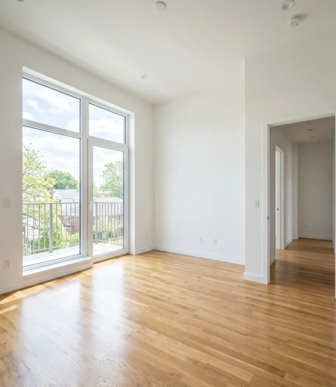 Frisch übergebenes, leeres Apartment im Tageslicht, saubere Böden, gewischte Fenster, kein Baustaub mehr, bereit für den ersten Möbelträger.