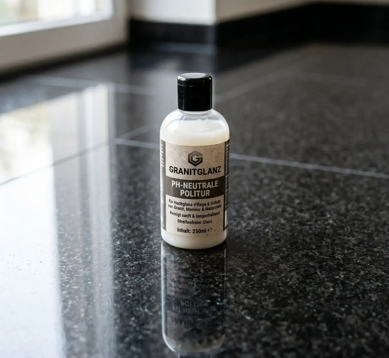 pH-neutrale Politurflasche von GRANITGLANZ neben polierter Steinoberfläche.