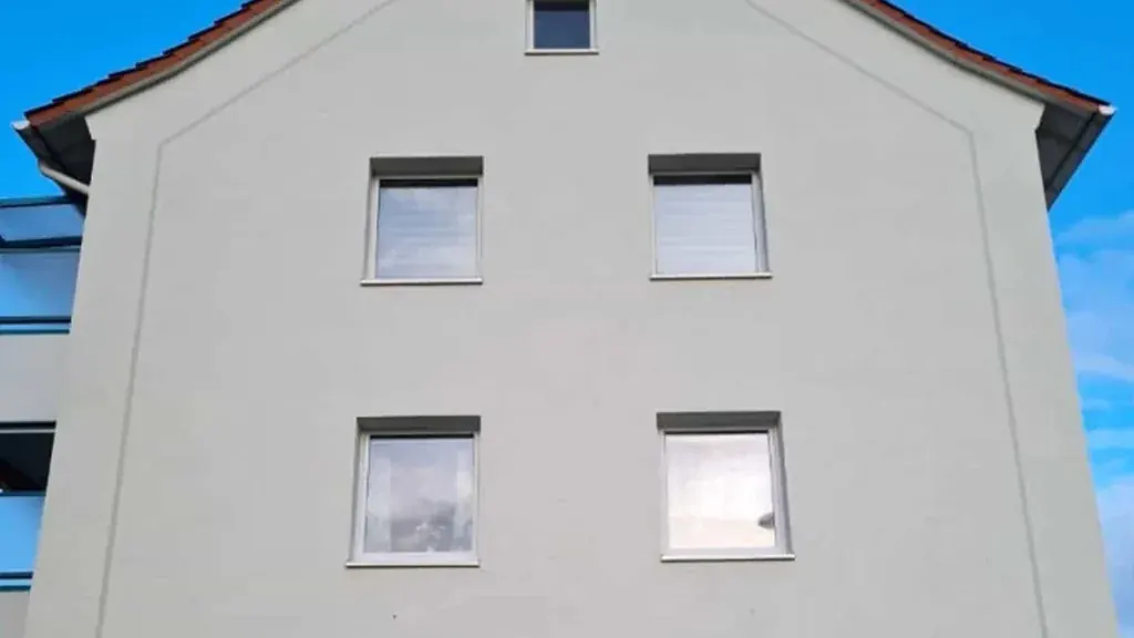 Dasselbe Mehrfamilienhaus mit frisch gereinigter Putzfassade nach der Reinigung in Hennef